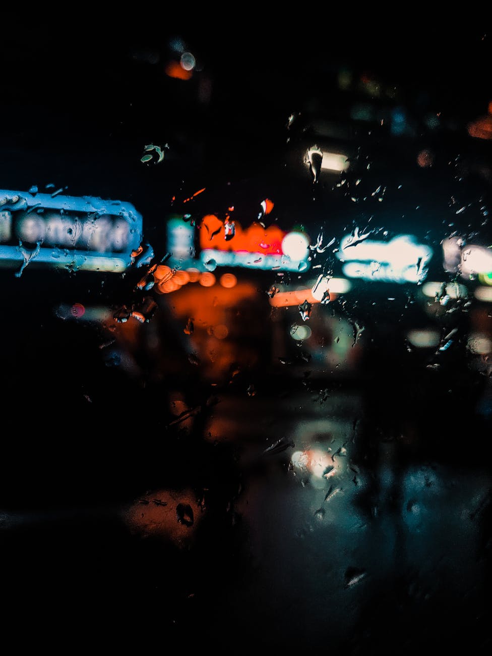 An abstract representation of a streetlight reflected in a rain-soaked window, with distorted lines and blurred shapes creating a unique and evocative image.