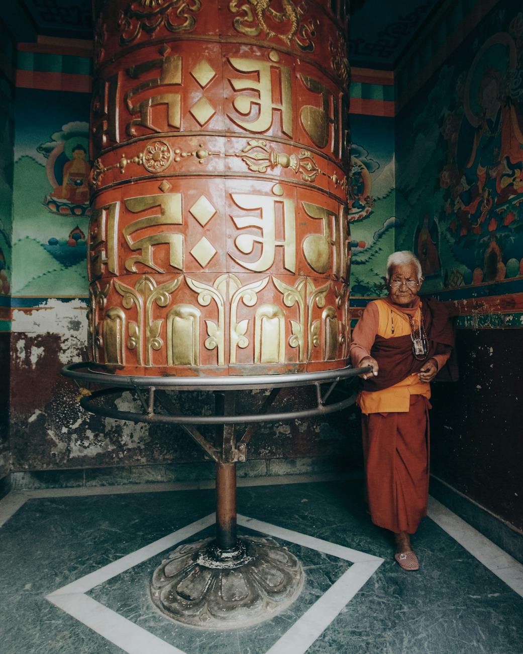 An ancient monk surrounded by scrolls in a monastery library.