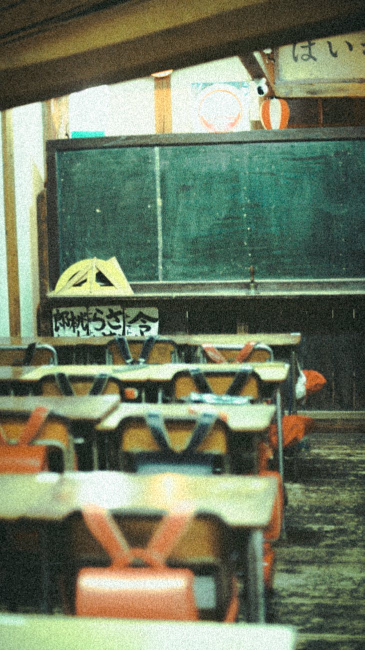 A dimly lit vintage classroom with a gaslight casting shadows.